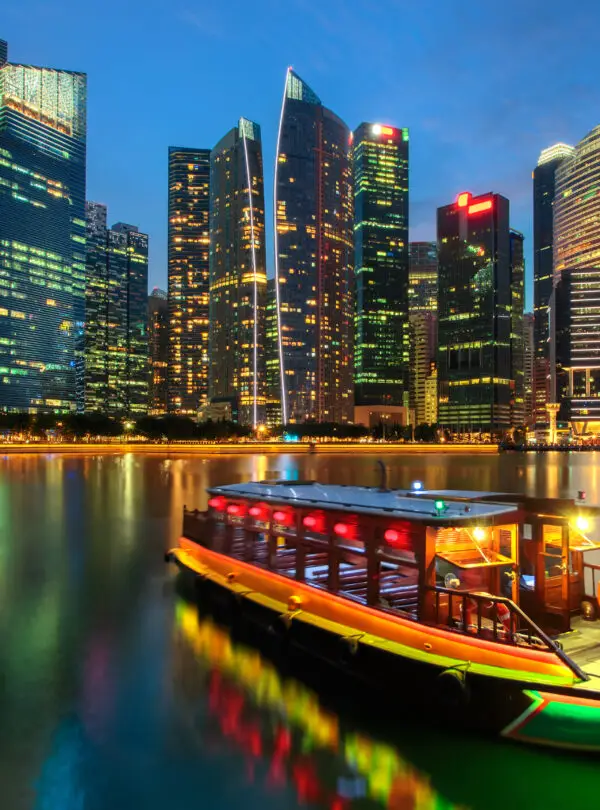 Singapore city skyline. Excursion cruise boat and business district view. downtown reflected in water at dusk in Marina Bay. Travel cityscape