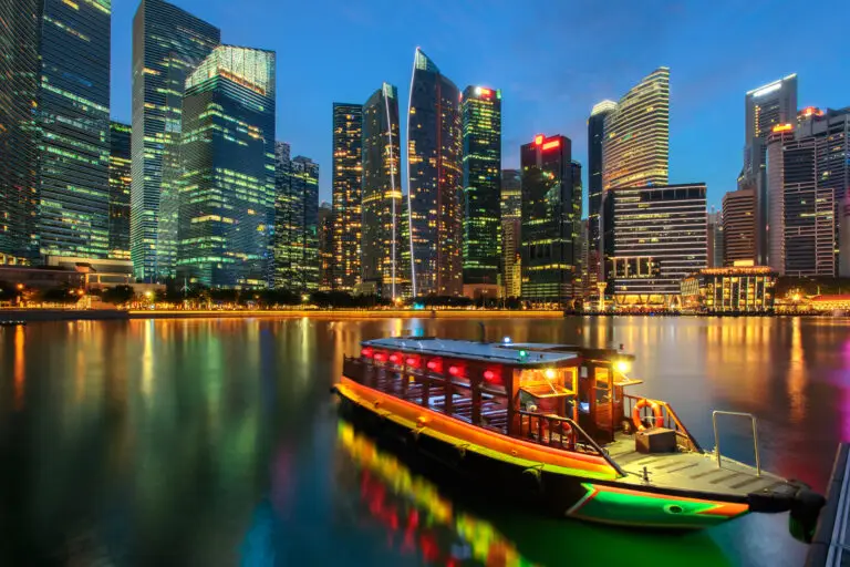 Singapore city skyline. Excursion cruise boat and business district view. downtown reflected in water at dusk in Marina Bay. Travel cityscape