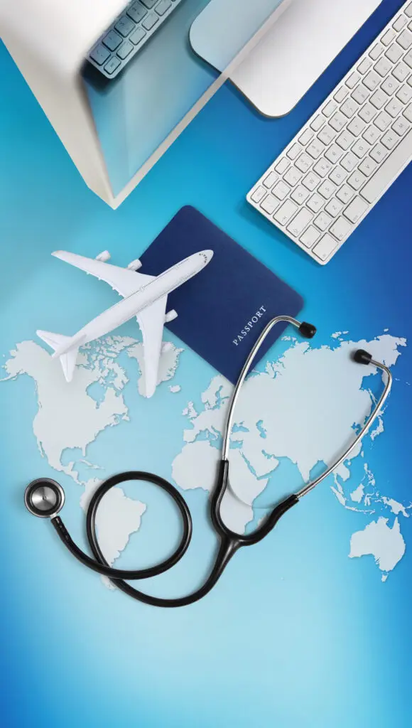 international medical travel concept, stethoscope, passport, computer and airplane on sky background with global map